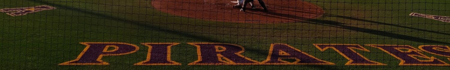 Pirates baseball game with "Pirates" painted on the outfield grass